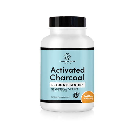 Bottle of activated charcoal capsules on a white background