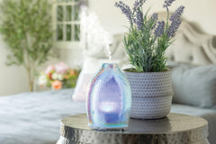 Airome diffuser illuminated with 8 LED colors for calming mood lighting and aromatherapy ambiance.