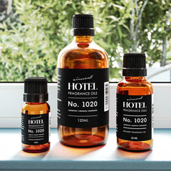 Bottled diffuser oil 1020 Bergamot Cardamom Sandalwood on glass surface