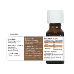 Aura Cacia Cedarwood bottle on a wooden surface