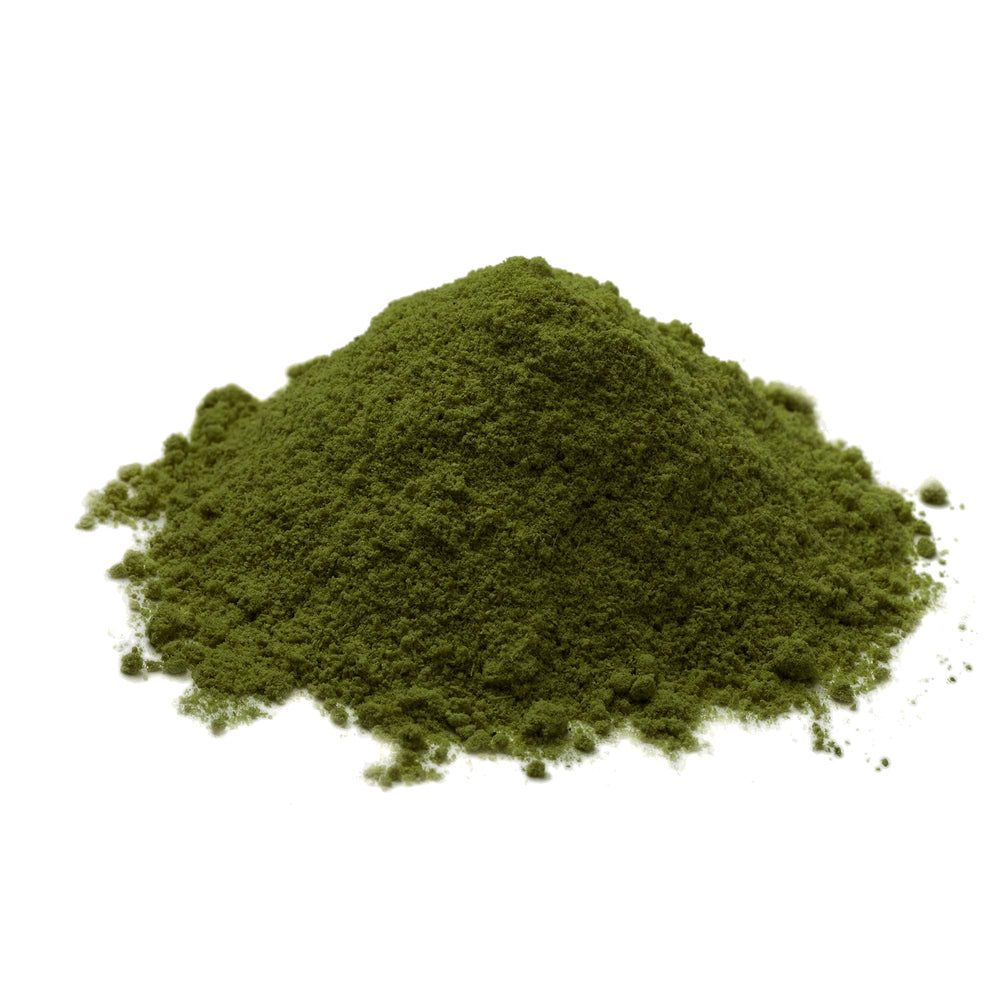 Chlorella powder being poured to show vibrant green color