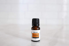 Close-up of citrus fruits and Citrus Delight essential oil bottle