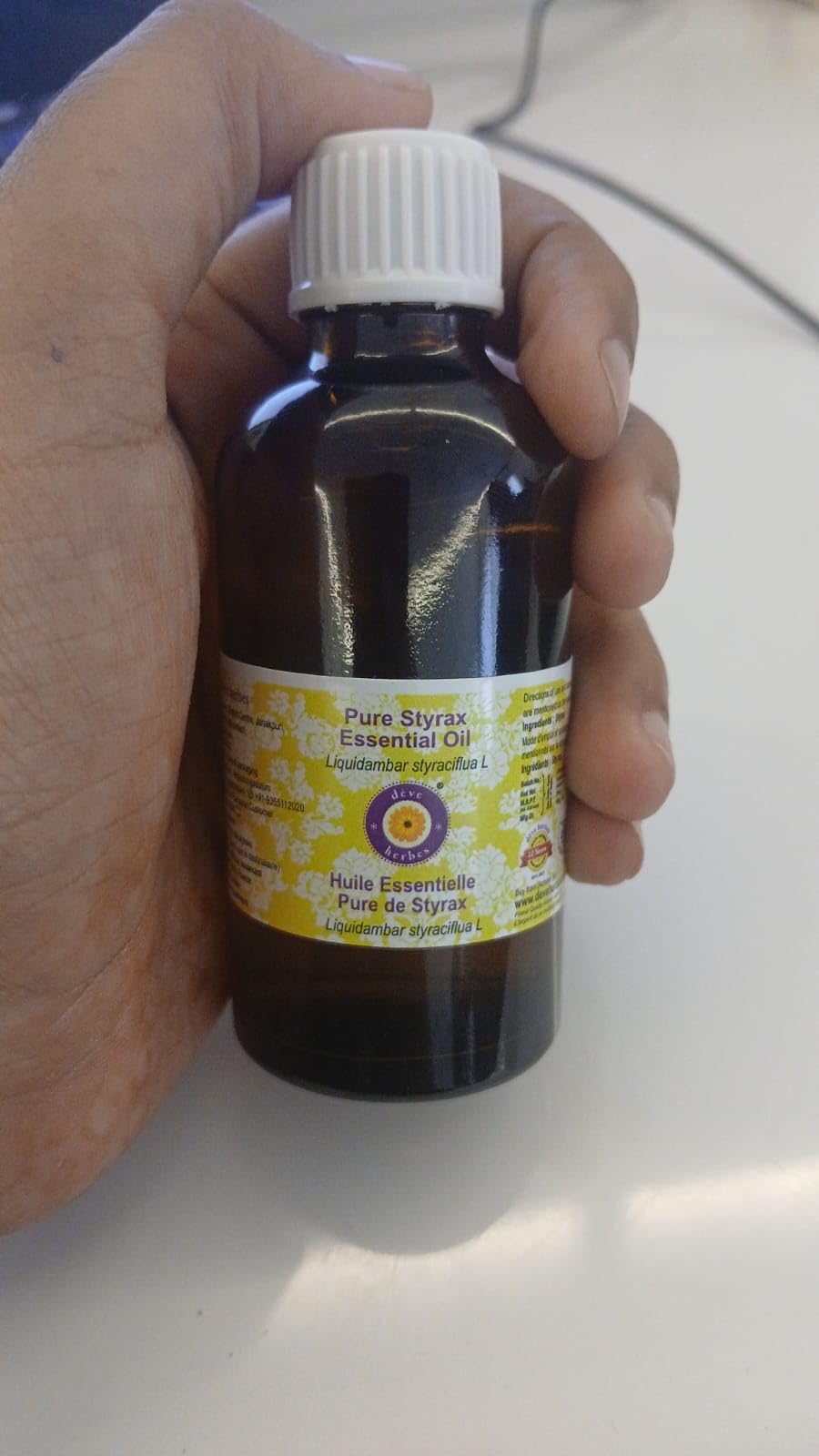 Amber glass bottle of Styrax essential oil on white background