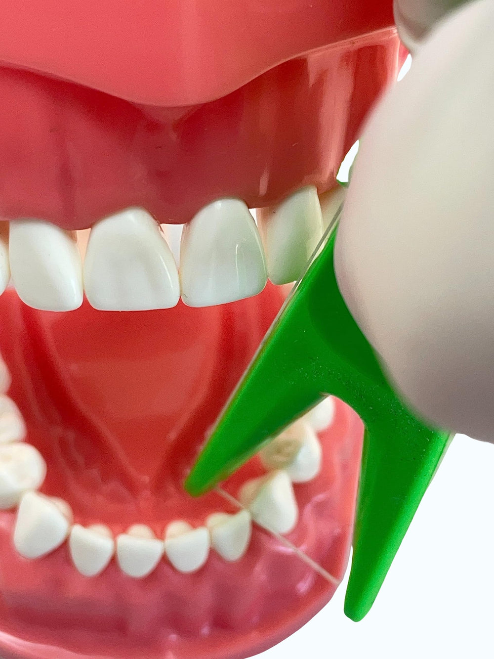 Child using E-Z Floss Holder with floss and Mr Flossman