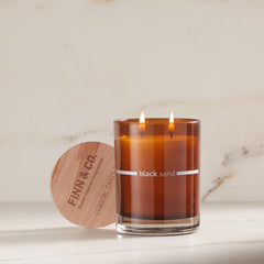 FINN & CO Black Sand candle amber glass jar ready for reuse.