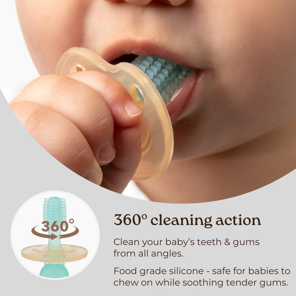Baby holding Haakaa 360° silicone toothbrush pink