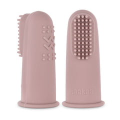 Blush Haakaa finger toothbrush held beside a hand