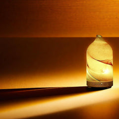 Aromatherapy diffuser on a nightstand with soft glow
