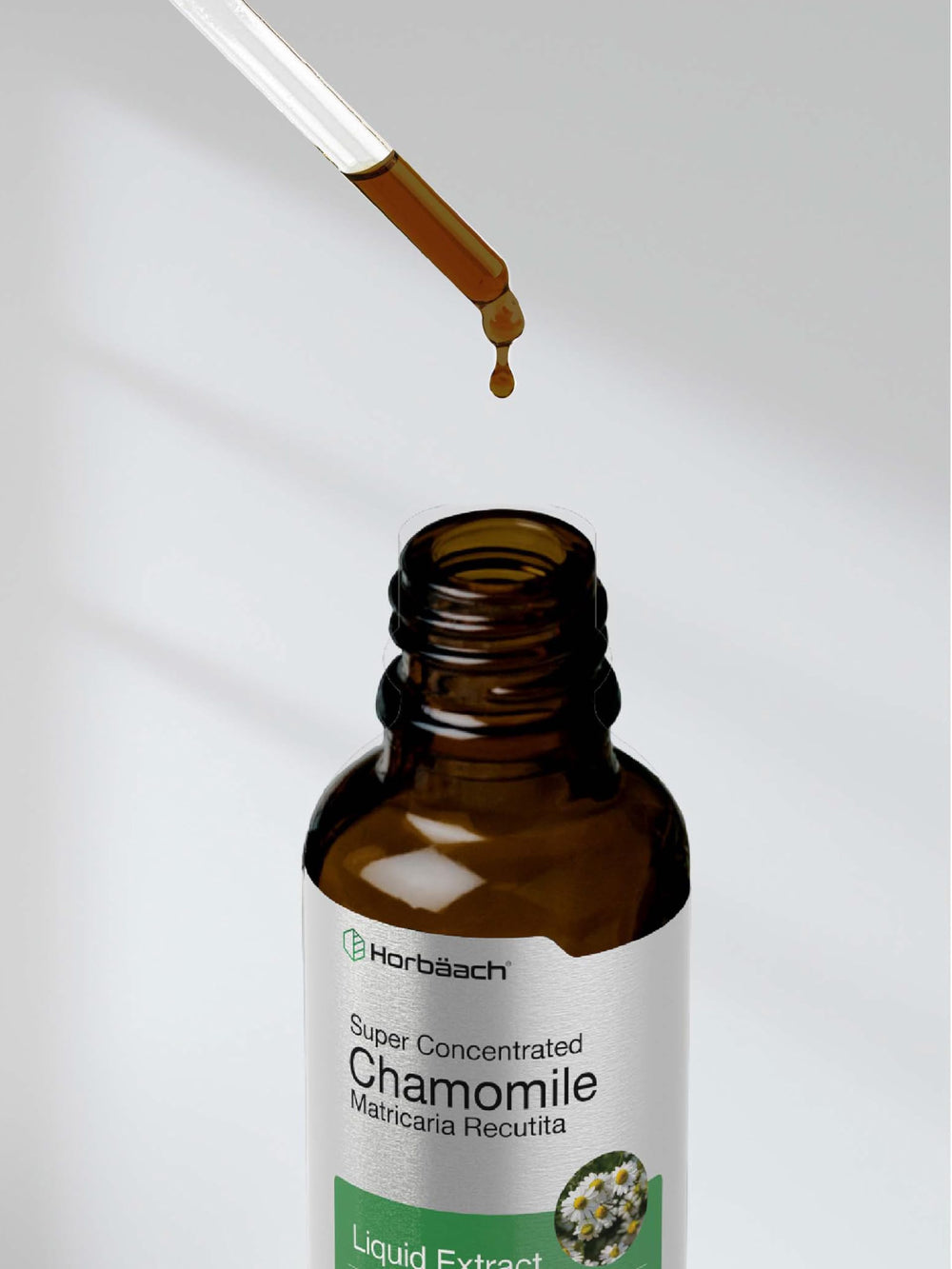Chamomile herb and Horbaach bottle together photograph