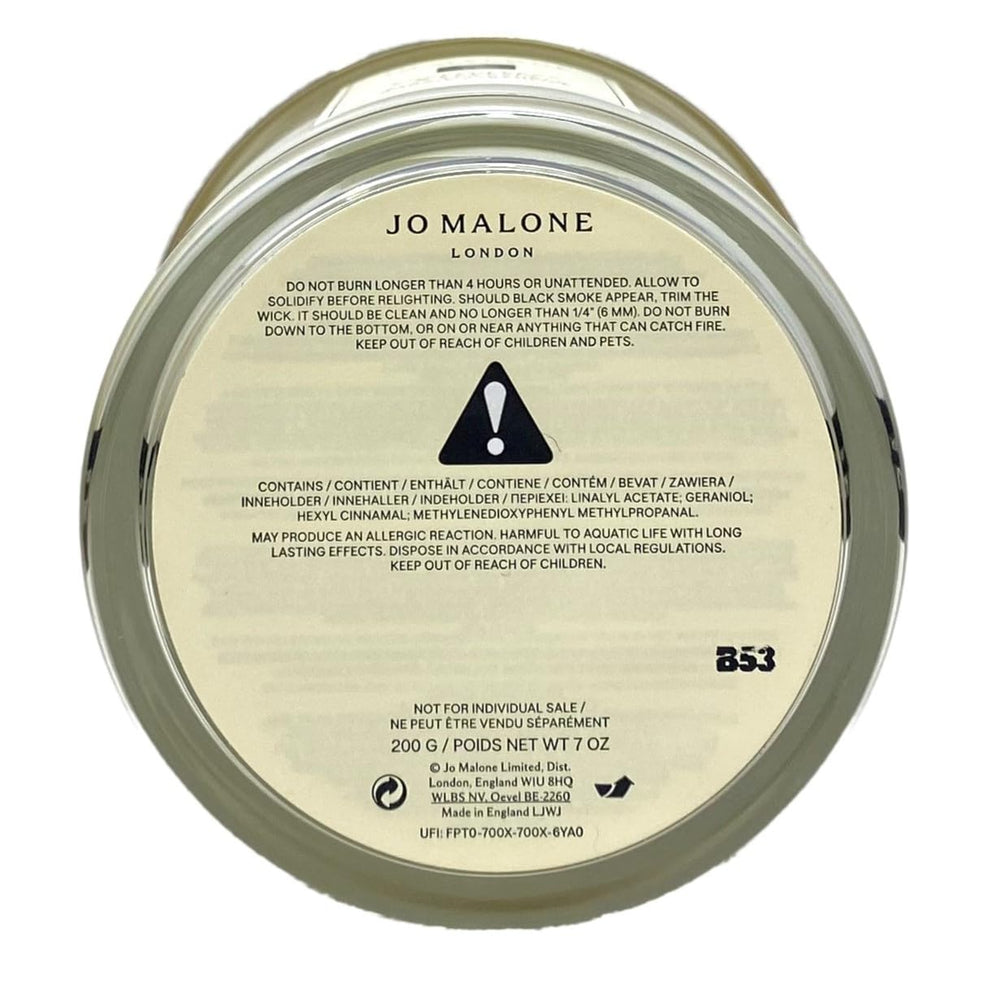 Jo Malone English Pear & Freesia candle jar on table enhances intimate room fragrance.