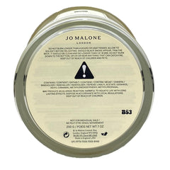 Jo Malone English Pear & Freesia candle jar on table enhances intimate room fragrance.