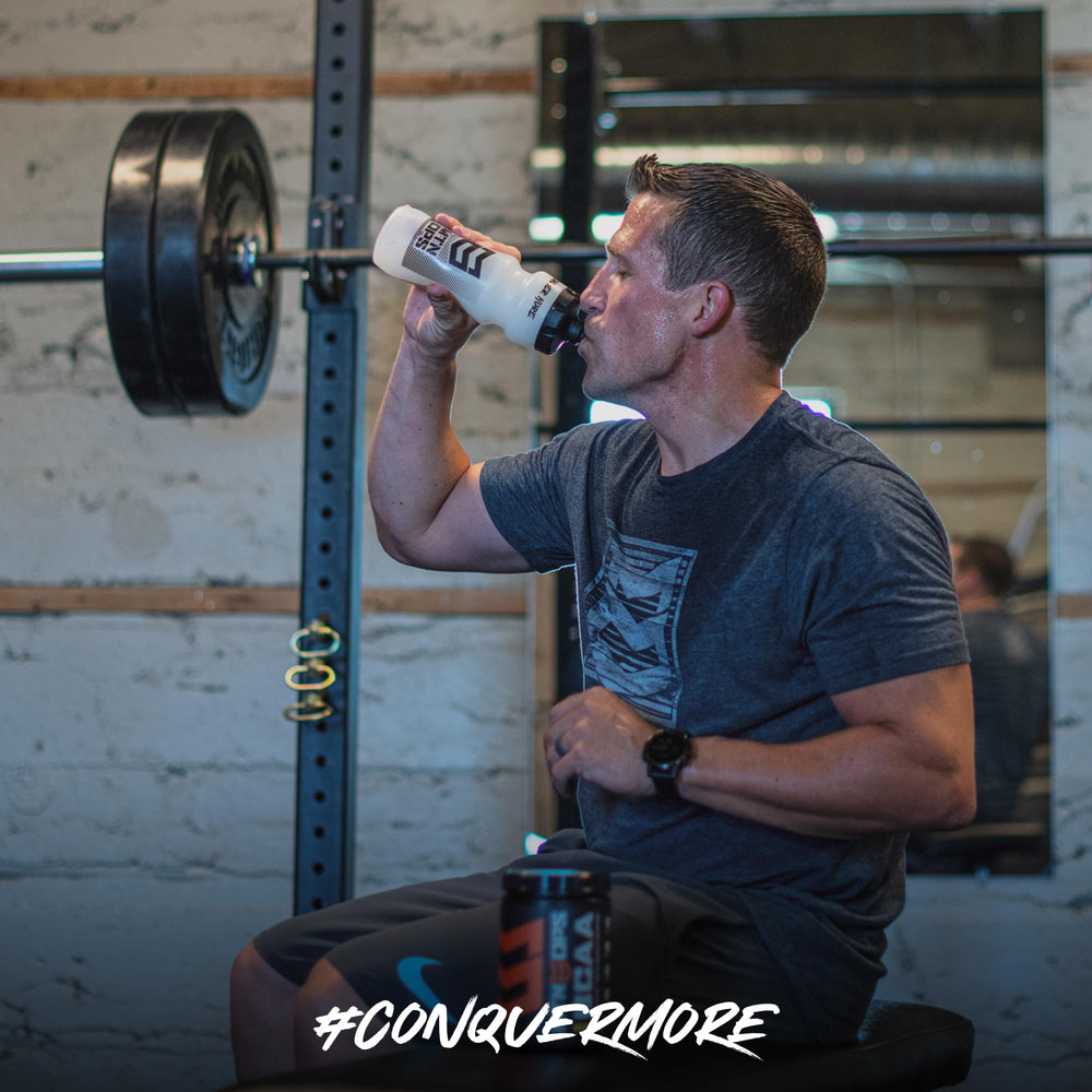 Pouring MTN OPS BCAA Peach Mango into glass