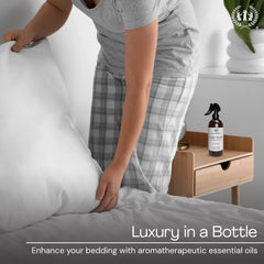Linen spray bottle displayed on bed linens with Lavender Serenity label
