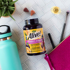 Lifestyle shot of a healthy woman taking Alive! gummies