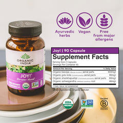 Joy Herbal Supplement bottle on desk with white background