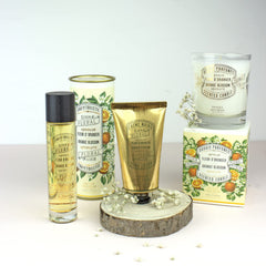 Candle displayed in Provence-inspired setting with citrus and blossoms