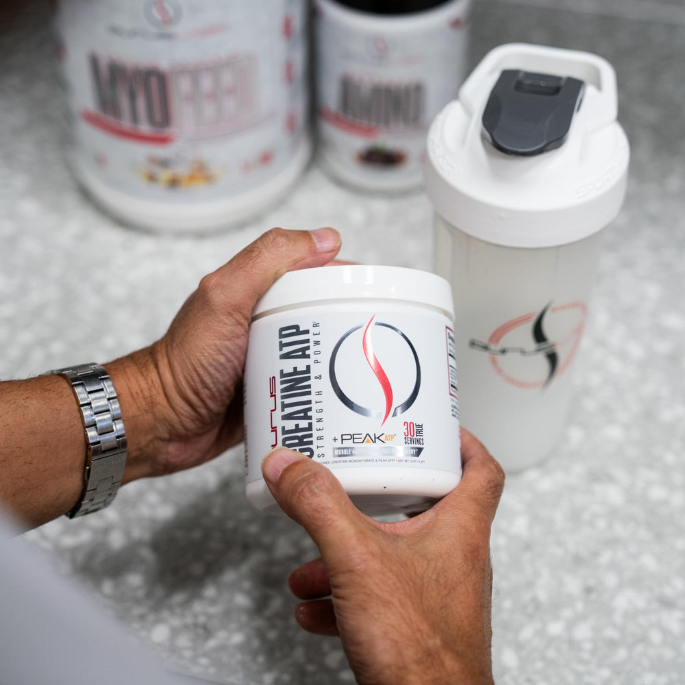 Serving scoop with creatine powder next to bottle