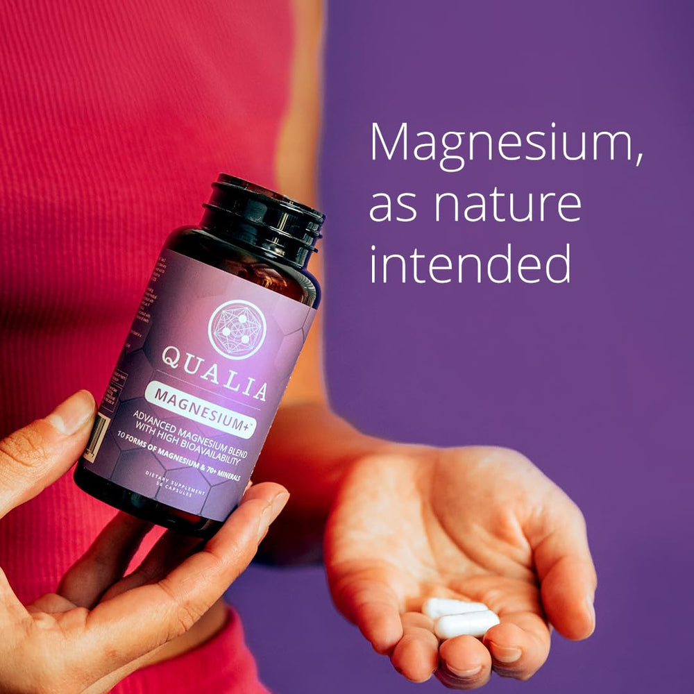 Qualia Magnesium+ lifestyle scene with glass of water and capsules.