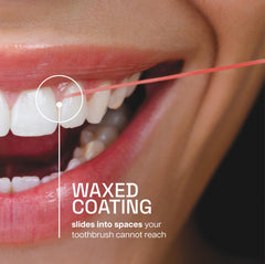Close-up of cinnamon-flavored waxed floss sliding between teeth