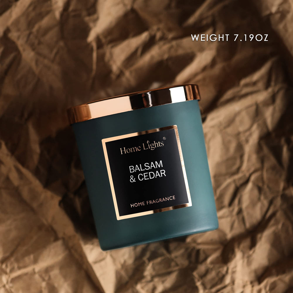 Candle with silky color glass and rosegold lid featuring balsam cedar scent
