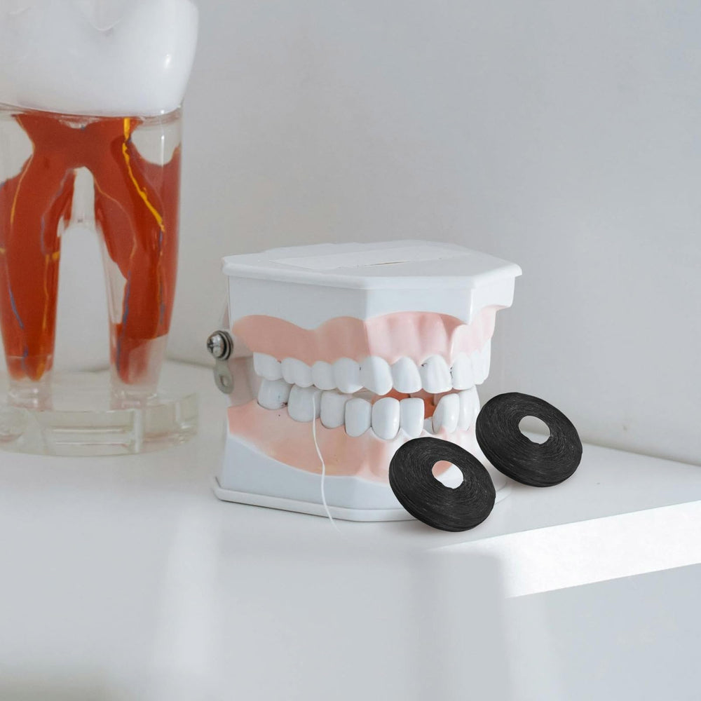 Dental floss roll spools with mint flavor and black color