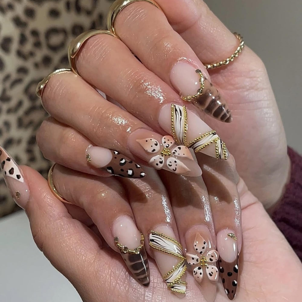 Brown almond nails featuring 3D floral details and gold accents for a chic look.