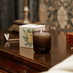 Unlit Sprig by Kohler Shield candle beside holiday decor
