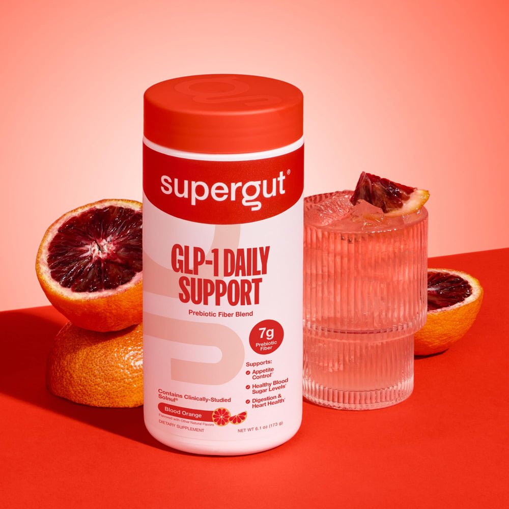 Scoop of GLP1 Daily Support powder next to glass