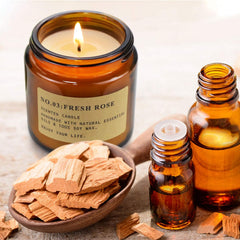Amber jar candle close-up with four scents: Mimurhyl, Fresh Rose, Cedar Teakwood, Sweet Grapefruit