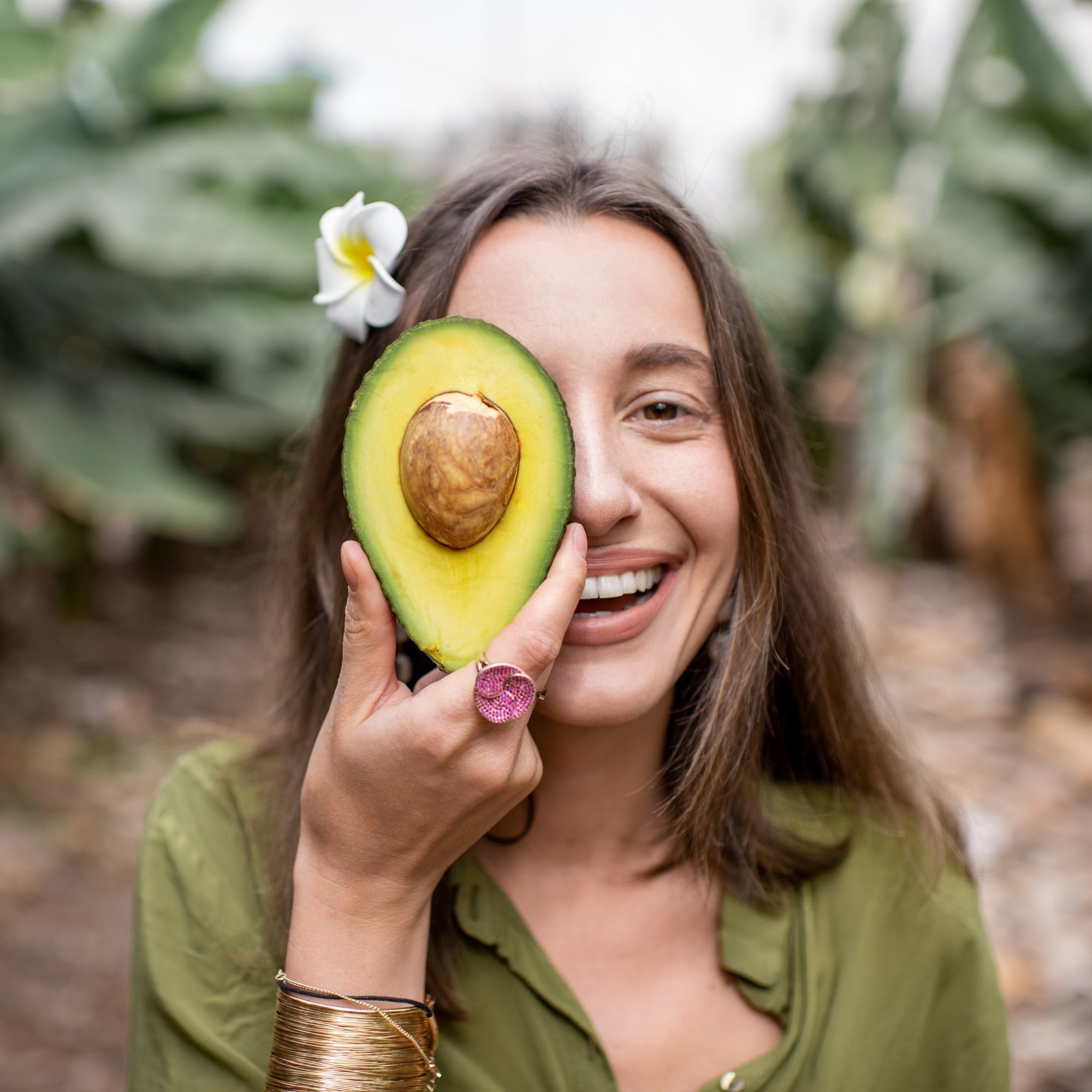 Woman holding avocado representing natural Antioxidants nutrition, healthy fats and wellness supplements lifestyle in the UK
