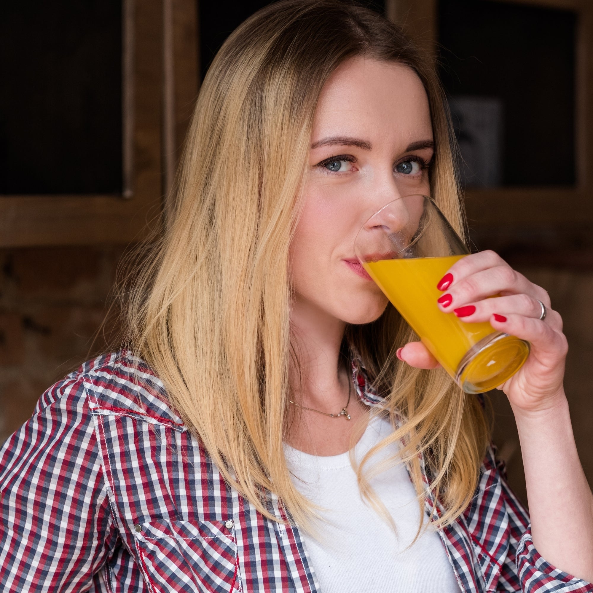Woman drinking fresh juice, symbolising daily vitamins for energy, immunity, and overall wellbeing support