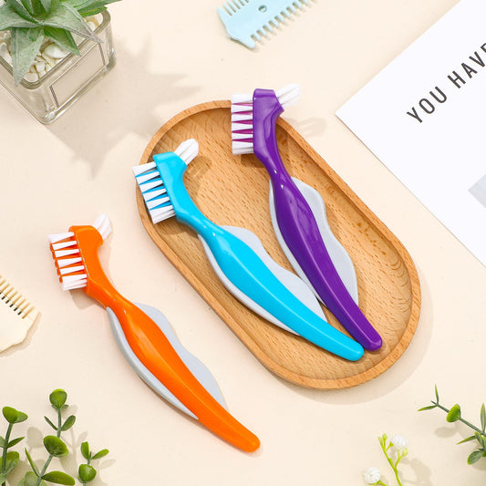 Orange dual-head denture cleaning brush with angled head