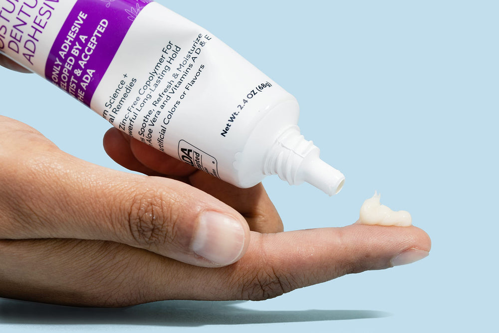 Close-up of Adhesadent moisturizing denture adhesive packaging