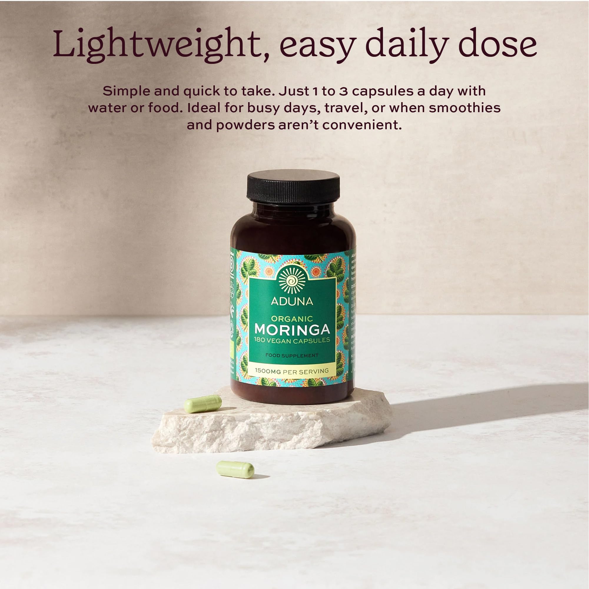 Hands holding Aduna Moringa Capsules bottle