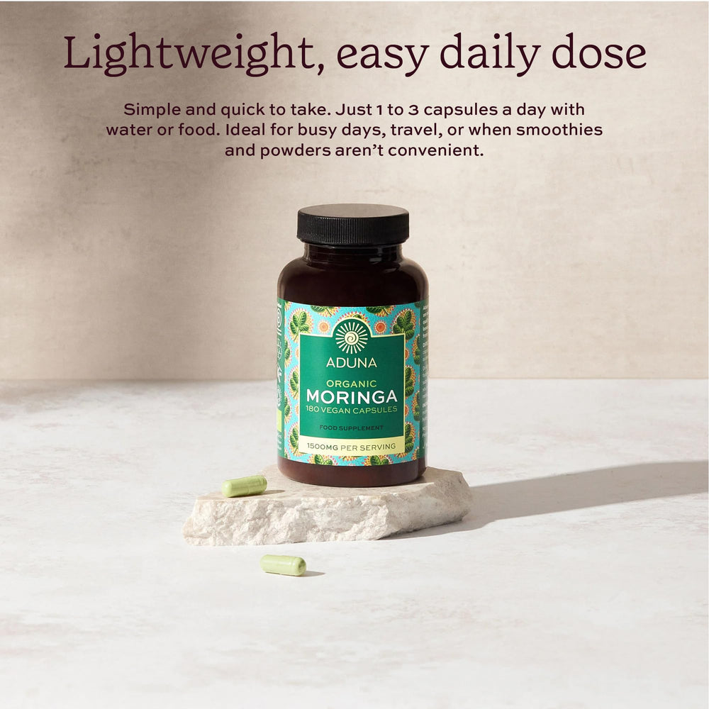 Hands holding Aduna Moringa Capsules bottle