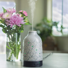 Close-up of Airome Jasmine diffuser showing gray ceramic sleeve with quatrefoil pattern