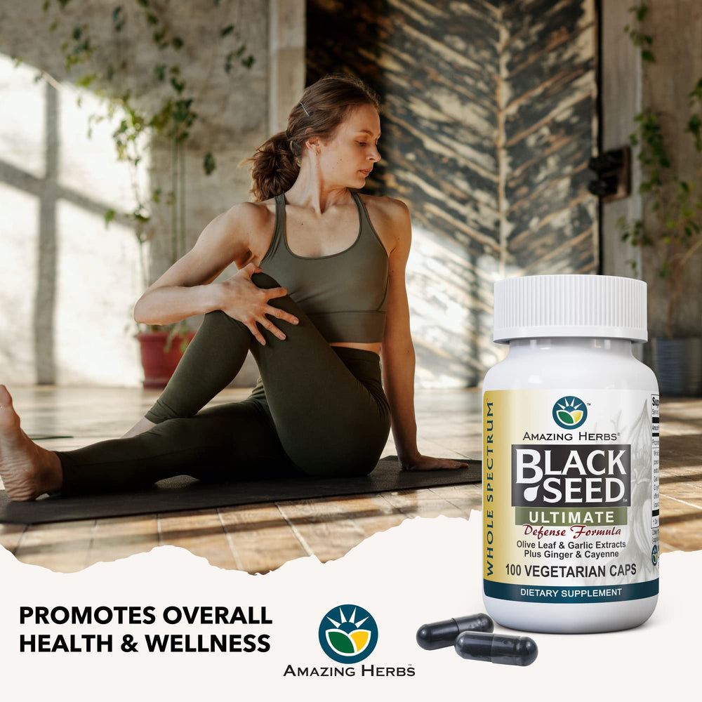 Person holding Amazing Herbs Black Seed Ultimate bottle for wellness
