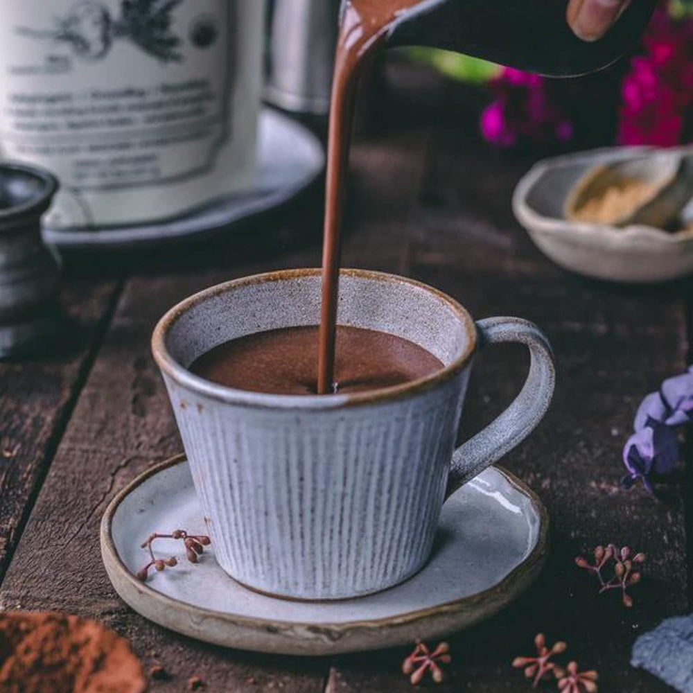 Powdered supplement in a scoop next to a glass