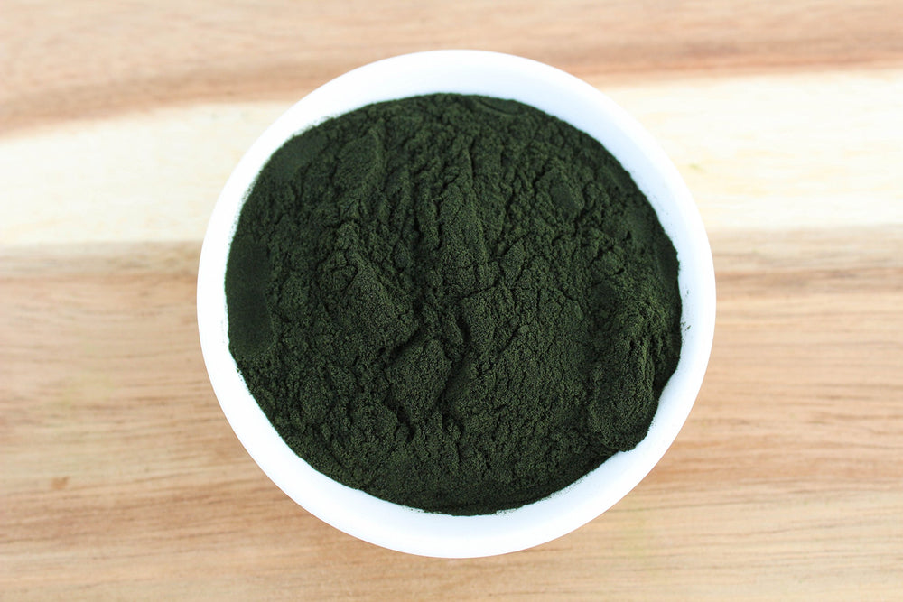 Chlorella powder being blended into a green smoothie