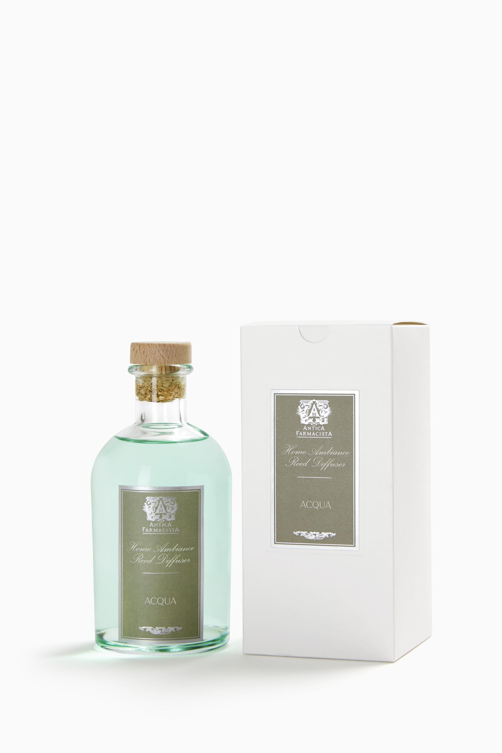 Close-up of Antica Farmacista Acqua reed diffuser in a glass bottle with reeds
