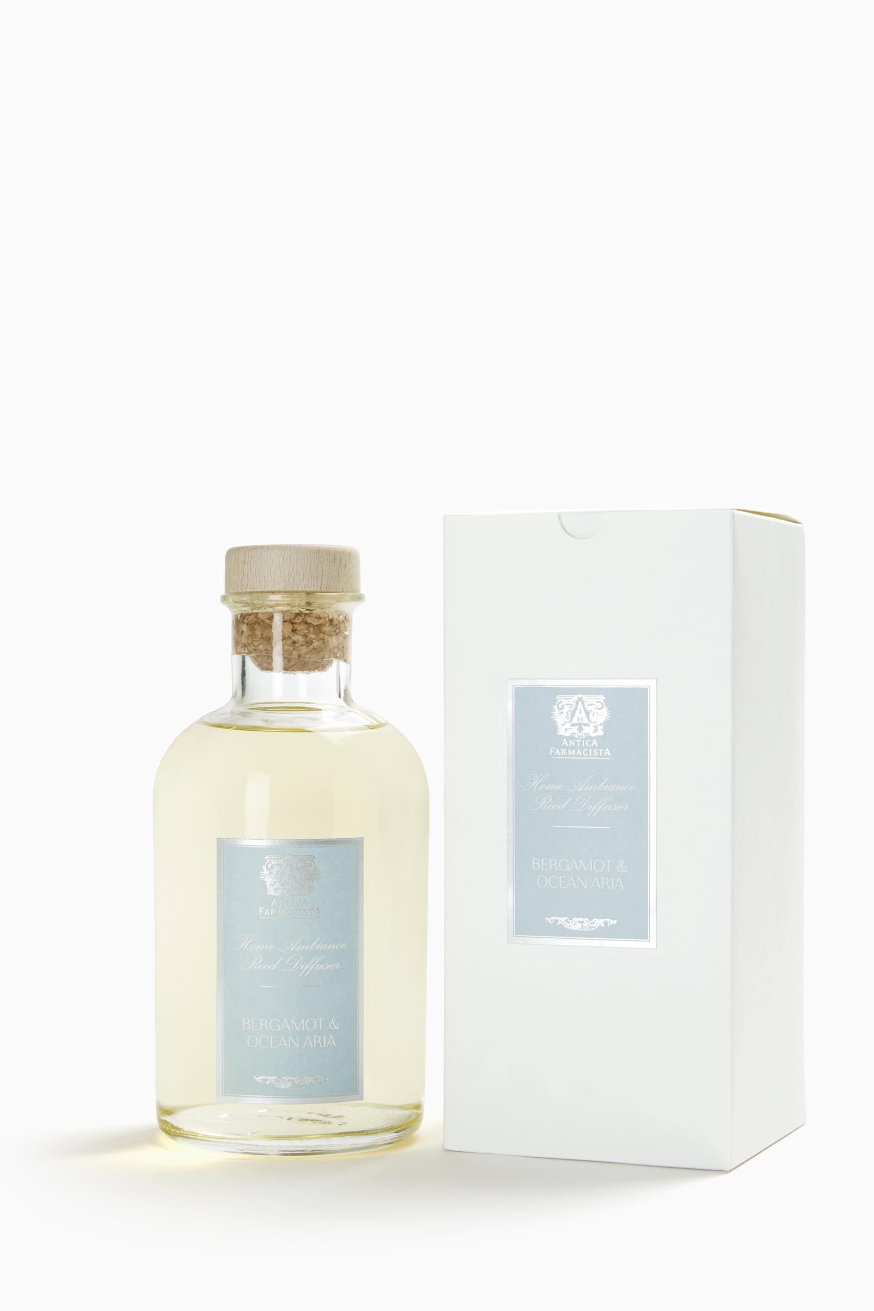Close-up of Antica Farmacista 16.9 oz glass diffuser bottle with reeds