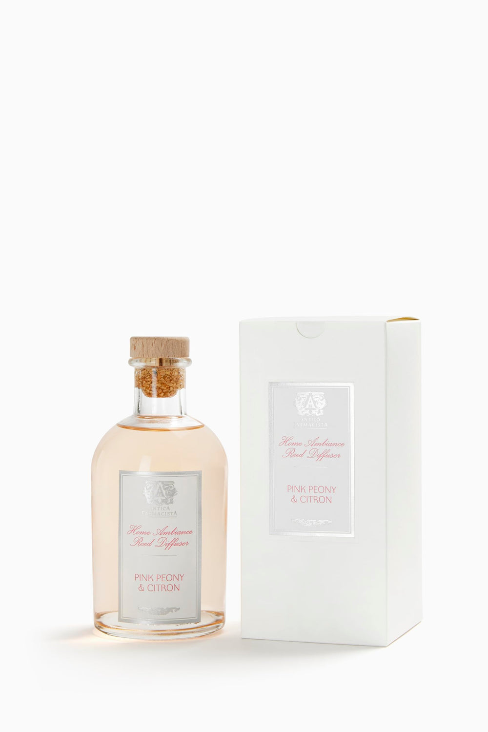 Close-up of Antica Farmacista diffuser bottle showing Pink Peony & Citron scent with reeds
