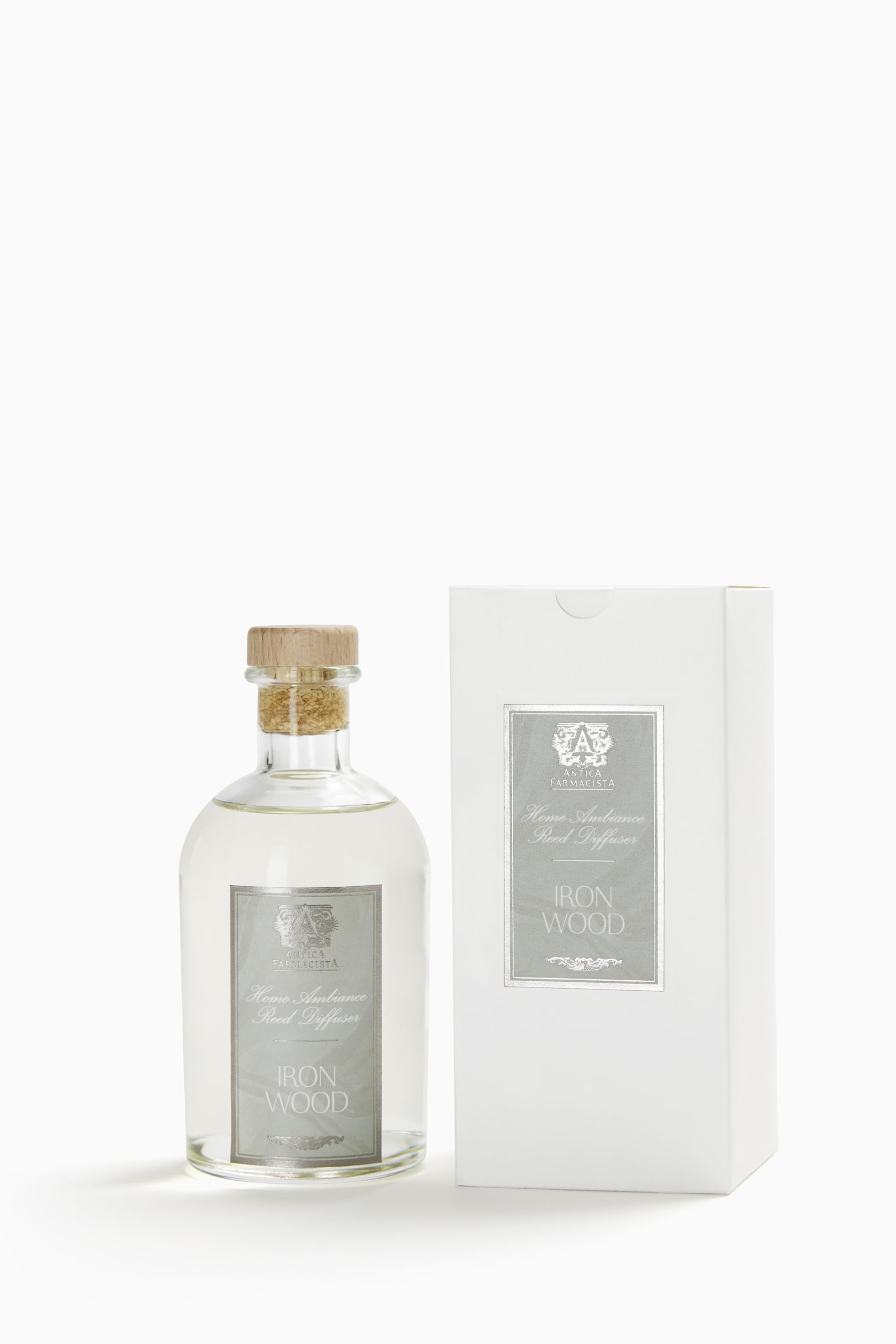 Close-up of Antica Farmacista Ironwood diffuser bottle and reeds