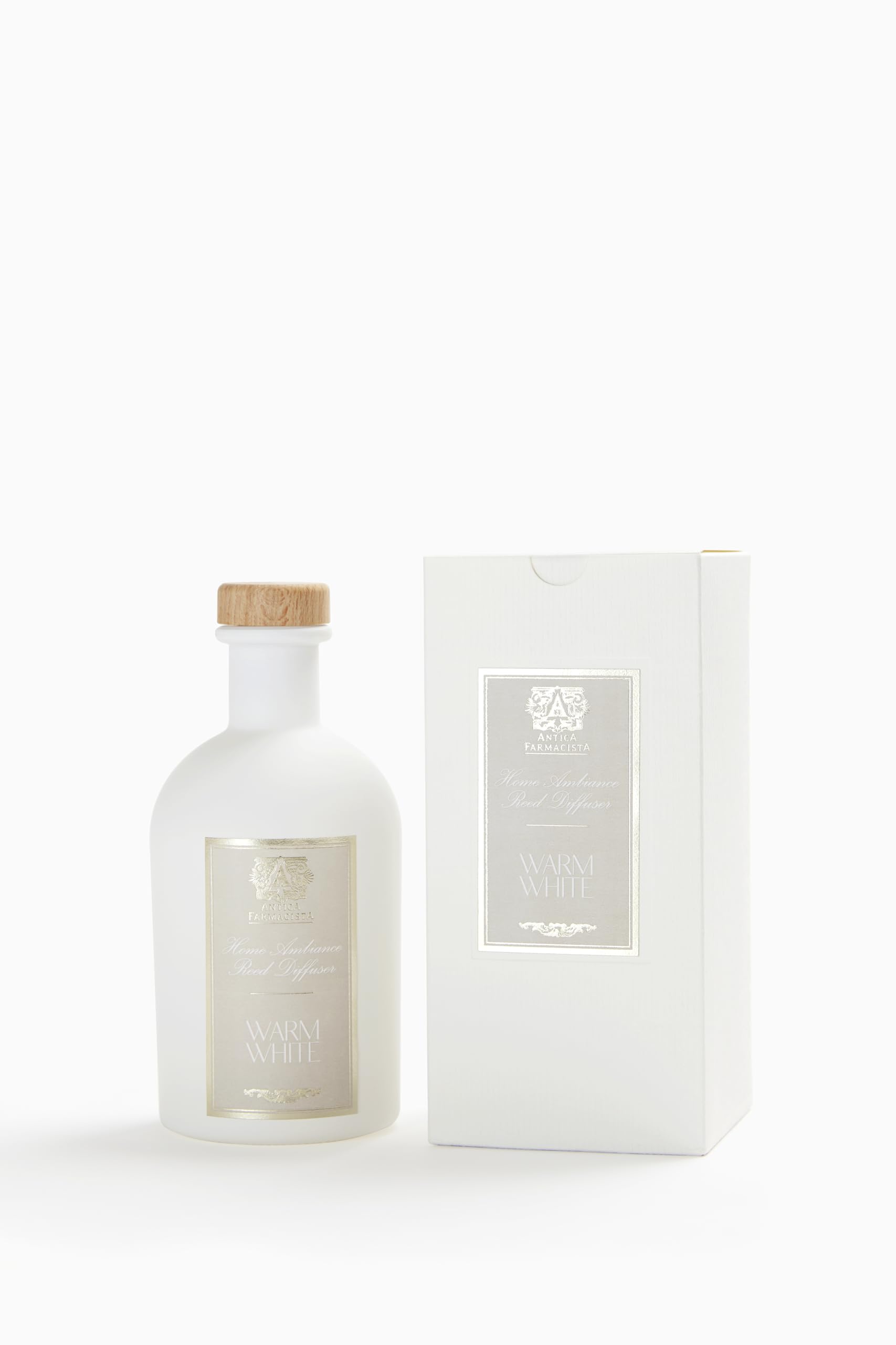 Close-up of Antica Farmacista Warm White diffuser with reeds in a cozy setting