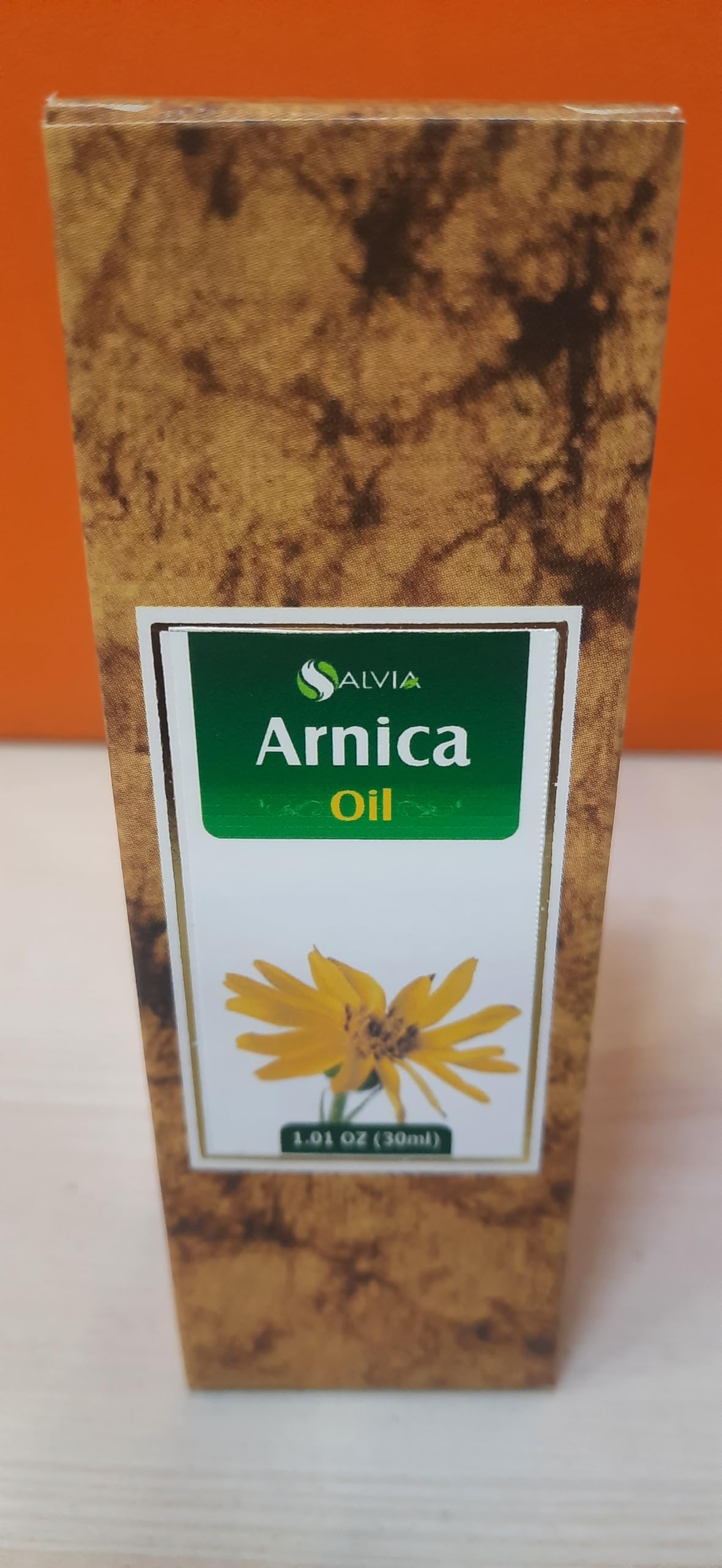 Amber glass bottle of Arnica essential oil