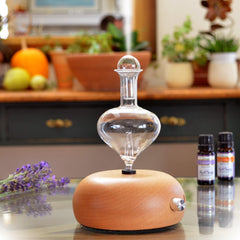 Close-up of glass reservoir and natural pine wood base in ArOmis waterless diffuser