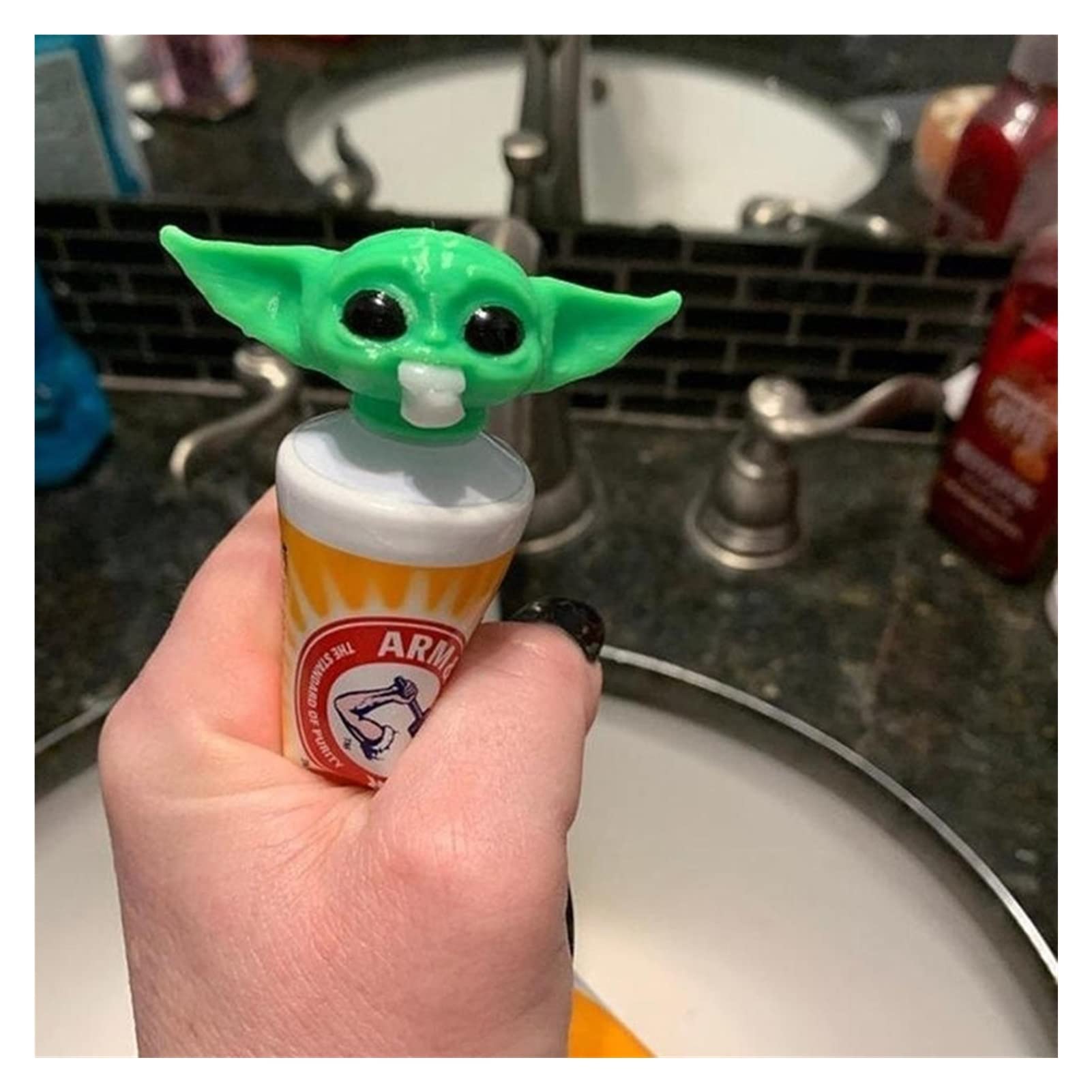 Angle view of Baby Yoda toothpaste cap topper