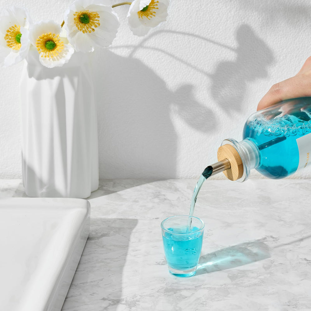 Mouthwash bottle resting on a natural bamboo tray