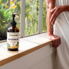 8 oz bottle of Banyan Botanicals Vata Massage Oil on a wooden surface