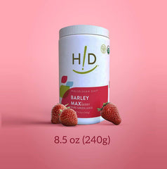 Pouring BarleyMax Berry powder into a glass of juice